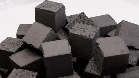 Pressed black coal cubes stacked in pile on white surface displaying detailed Stock Footage 311326102