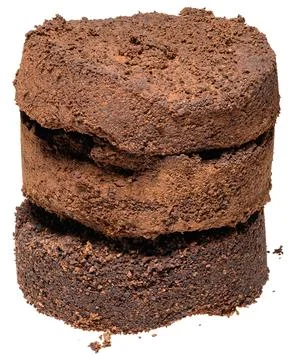 Pressed tablet of used ground coffee, coffee puck or cake, isolated backgroun Stockfoto's