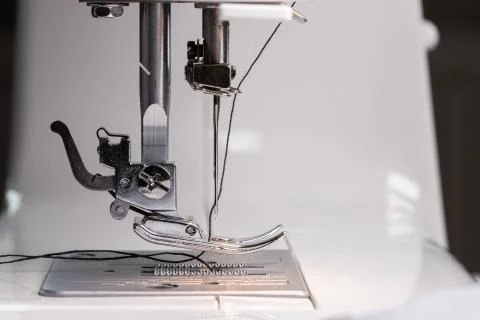 Presser foot with needle and thread. Sewing equipment. Close-up of the workin Stock Photos