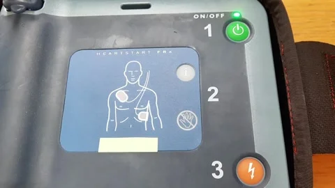 Pressing the AED power button to turn it on and use a patient in cardiac arrest Stock Footage 288974694