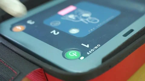 Pressing the AED power button to turn it on and use a patient in cardiac arrest Stock Footage 322116109