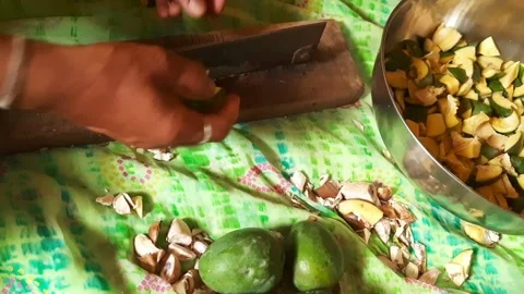 Pressing and Slicing Raw Green Mangoes Using Traditional Cutter Stock Footage 336906549