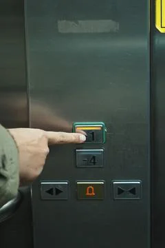 Pressing the button for the first floor in an elevator Foto stock