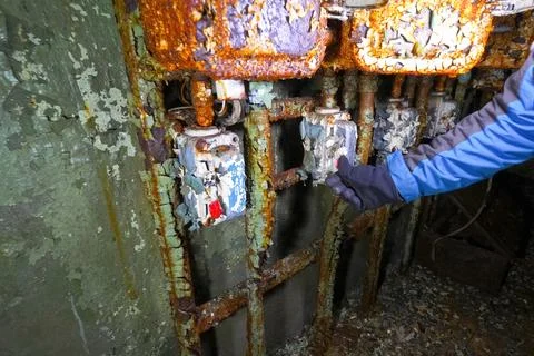 Pressing a button by hand on the control panel in an old abandoned bunker wit Stock Photos
