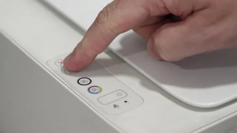 Pressing buttons on a printer to start a print job at an office desk Stock Footage 332422458