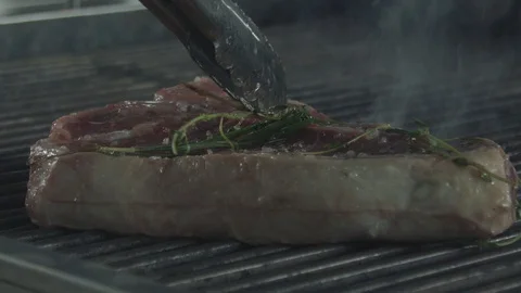 Pressing down a beef steak with the kitchen tongs, while it frying Stock Footage 92179949