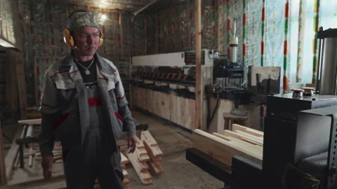 Pressing down on planks for processing using the industrial sawing equipment Stock Footage 171956702