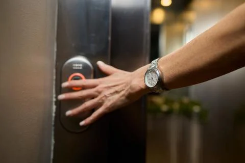 Pressing the elevator button in contemporary high rise buildings signifies Stock Photos