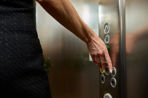 Pressing the elevator button in contemporary high rise buildings signifies Stock Photos