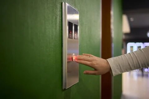 Pressing the elevator button in contemporary high rise buildings signifies Stock Photos