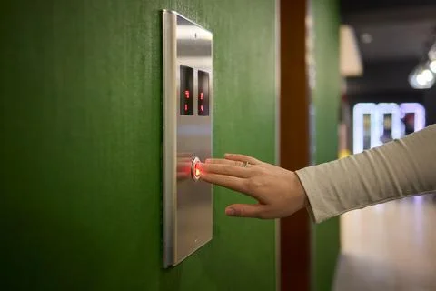 Pressing the elevator button in contemporary high rise buildings signifies Stock Photos