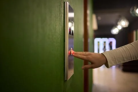 Pressing the elevator button in contemporary high rise buildings signifies Stock Photos