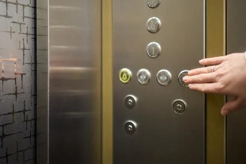 Pressing the elevator button in contemporary high rise buildings signifies Stockfoto's