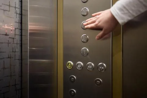 Pressing the elevator button in contemporary high rise buildings signifies Stockfoto's