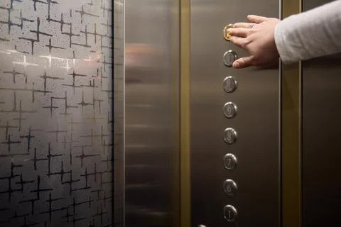 Pressing the elevator button in contemporary high rise buildings signifies Stock Photos