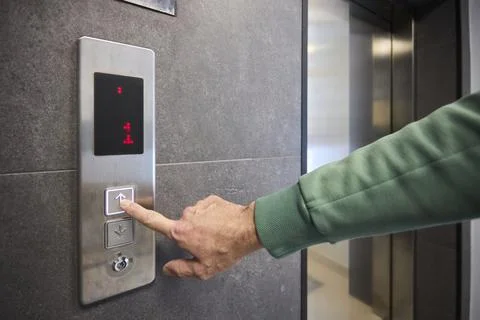 Pressing the elevator button in contemporary high rise buildings signifies Fotos de archivo