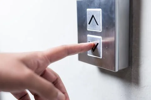 Pressing elevator button, person selecting floor in modern office building Foto stock