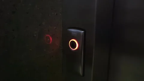 Pressing a finger on the call button of a modern elevator, close-up. Freight Stock Footage 295603475