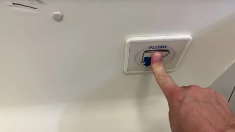 Pressing Flush Button in Airplane Lavatory Close-Up Sequence Video stock 320986750
