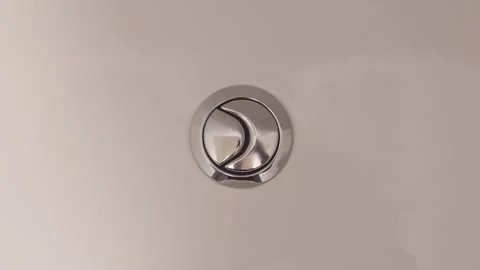 Pressing the flush button on a modern toilet cistern in a bathroom setting Video stock 310715133