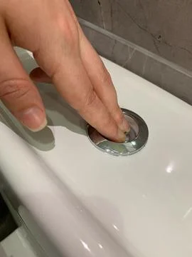 Pressing flush button on toilet to flush water Stock Photos