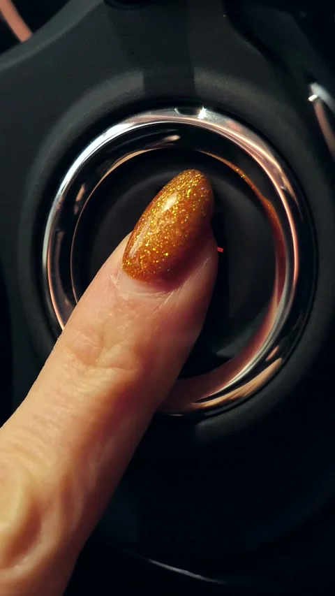 Pressing the ignition button by a female hand to start the car engine without a Stock Footage 317162801
