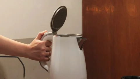 Pressing the lid release button of an electric kettle after boiling water Stock Footage 343334068
