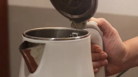 Pressing the lid release button of an electric kettle after boiling water 库存影片 343334124