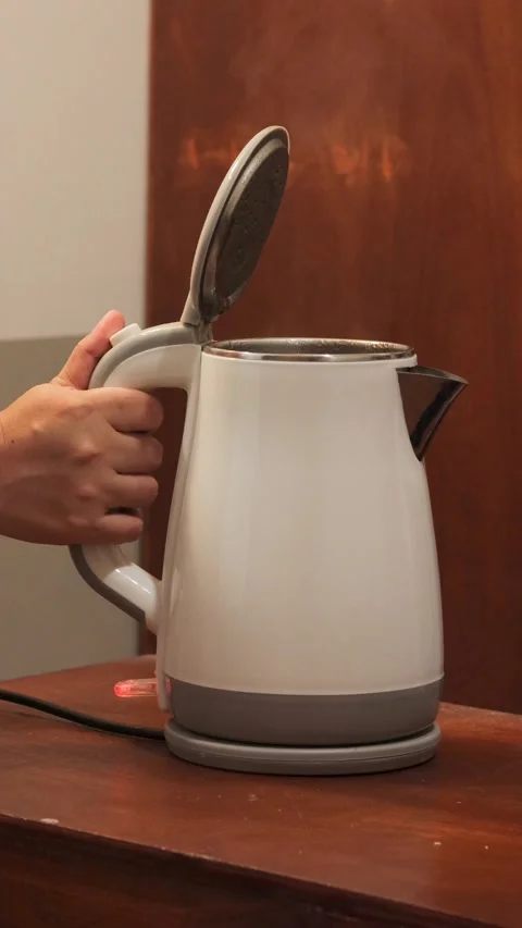 Pressing the lid release button of an electric kettle after boiling water Stock Footage 343334216