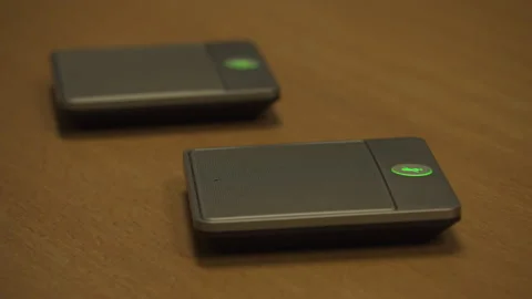 Pressing mute button on a remote microphone and speaker device, conference Stock Footage 131085663