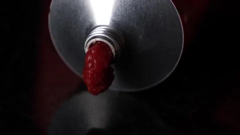 Pressing out red tomato puree of a aluminium tube, macro view Stock Footage 147346178