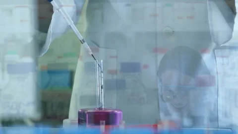 Pressing pipette, tech dispensing drop into tube on lab stand, overlay over Stock Footage 330397362