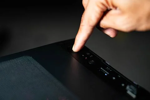 Pressing power button on computer case Stock Photos