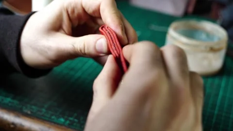 Pressing Red Leather Wallet Edges by Hand to Secure Glue Stock Footage 314961988