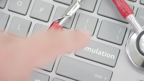 Pressing SIMULATION key on a keyboard near stethoscope Stock Footage 137211070