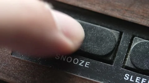 Pressing the Snooze Button on an Alarm Clock in the Morning Stockbeeldmateriaal 205721707