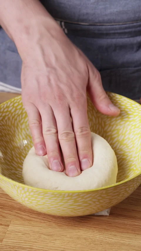 Pressing soft dough ball to check texture in mixing bowl Видео 330342465