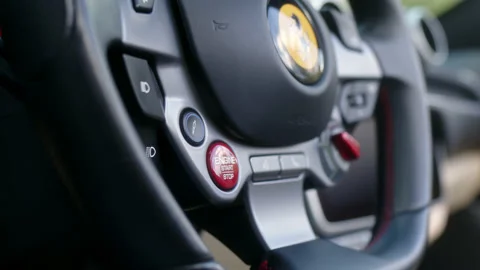 Pressing start button on the steering wheel. Starting the engine of a sports Stock Footage 204105418