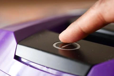 Pressing start button on vacuum cleaner. Stock Photos