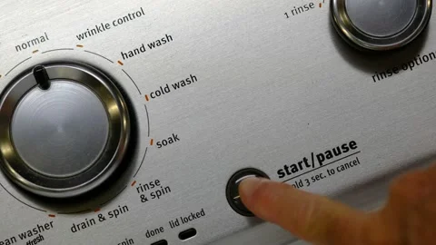 Pressing start button on a washing machine Stock Footage 138600024
