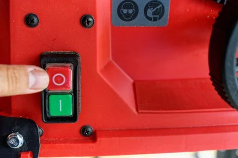 Pressing stop button on electric machine red table saw Stock Photos