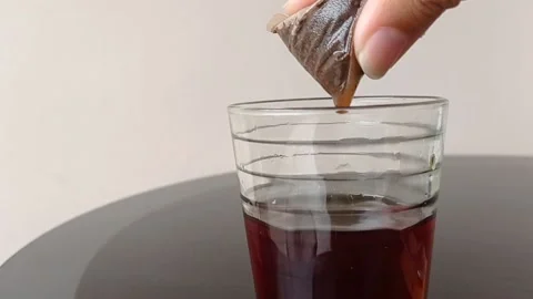 Pressing a teabag on a cup of a tea Stock Footage 145621622