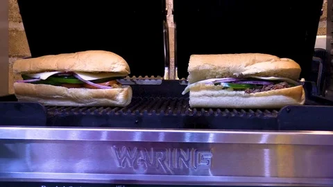 Pressing two sub sandwich on Panini grill Stock-Footage 105983602