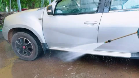 Pressure pump blasts dirt off car surface with ease Stock Footage 311632689