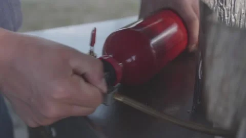Pressurize the liquid fuel bottle for making fire Stock Footage 87892706