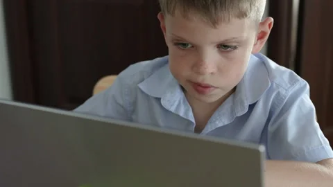 Preteen boy is deeply engaged in working on his laptop at home. Stock Footage 310360733