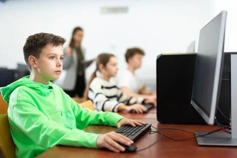 Preteen boy learning basics of programming in computer college 库存照片