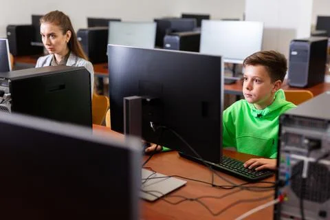 Preteen boy learning basics of programming in computer college 库存照片