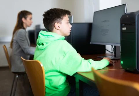 Preteen boy learning basics of programming in computer college Foto stock
