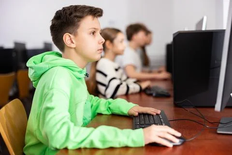 Preteen boy learning basics of programming in computer college Foto stock
